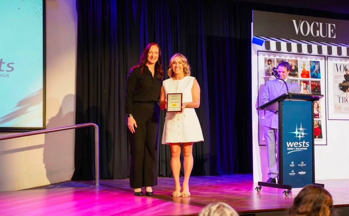 An award being presented on stage at a Wests Macarthur luncheon